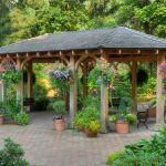 this patio gazebo houses a few benches and a number of potted plants. UAHSQXW
