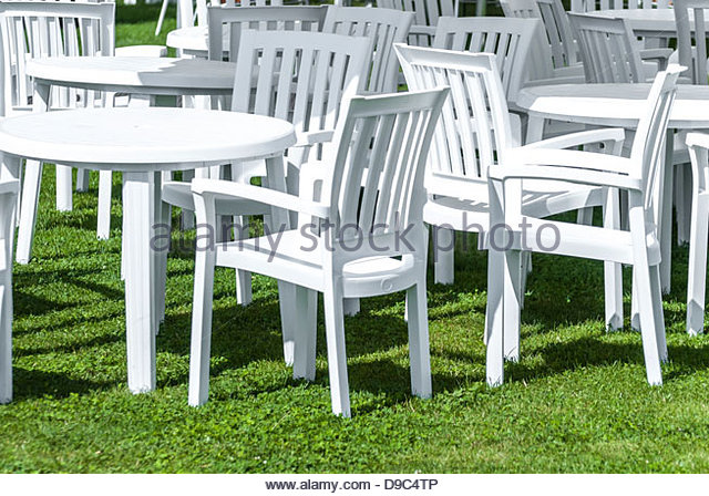 white plastic garden furniture on a lawn. - stock image NWVGTFF