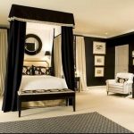 THIS BLACK AND WHITE BEDROOM BOASTS A LUXURIOUS DRAPED CANOPY .