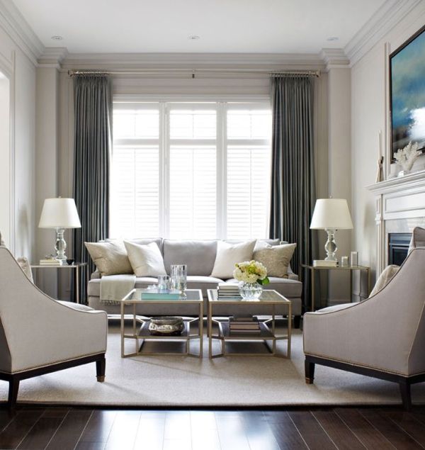 Elegant living room, with light grey sofa and arm chairs with .