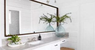 Cottage master bathroom designed with a seagrass x stool under a .