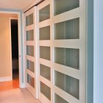 botanica white and glass sliding closet doors modernize this master bedroom  closet OENHBMR