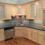 light maple kitchen cabinets with solid grey countertop and grey backsplash GNMKTBY