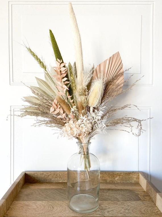 Textured glass vases filled with dried flowers for a natural touch in the boho bathroom