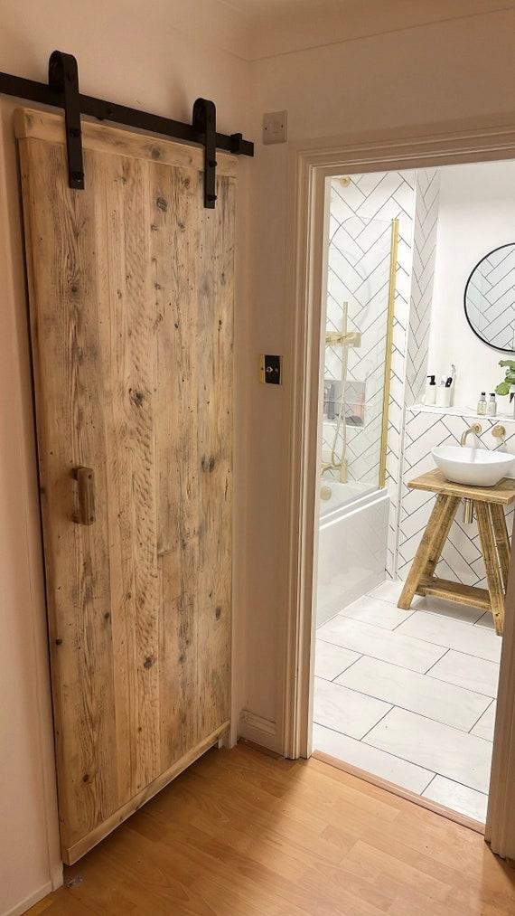 Create a rustic wooden⁤ bathroom⁣ with barn door accents