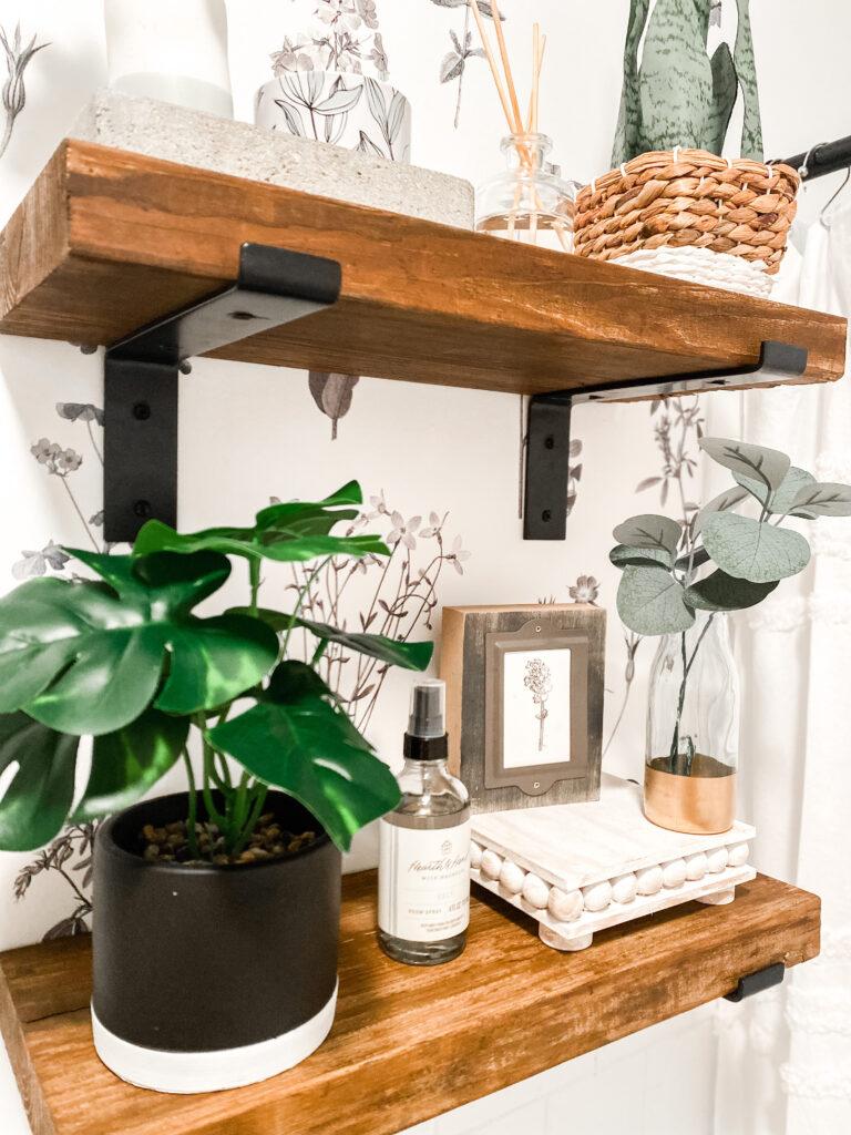 Floating shelves exhibit curated knick-knacks, enhancing your​ eclectic bathrooms personality