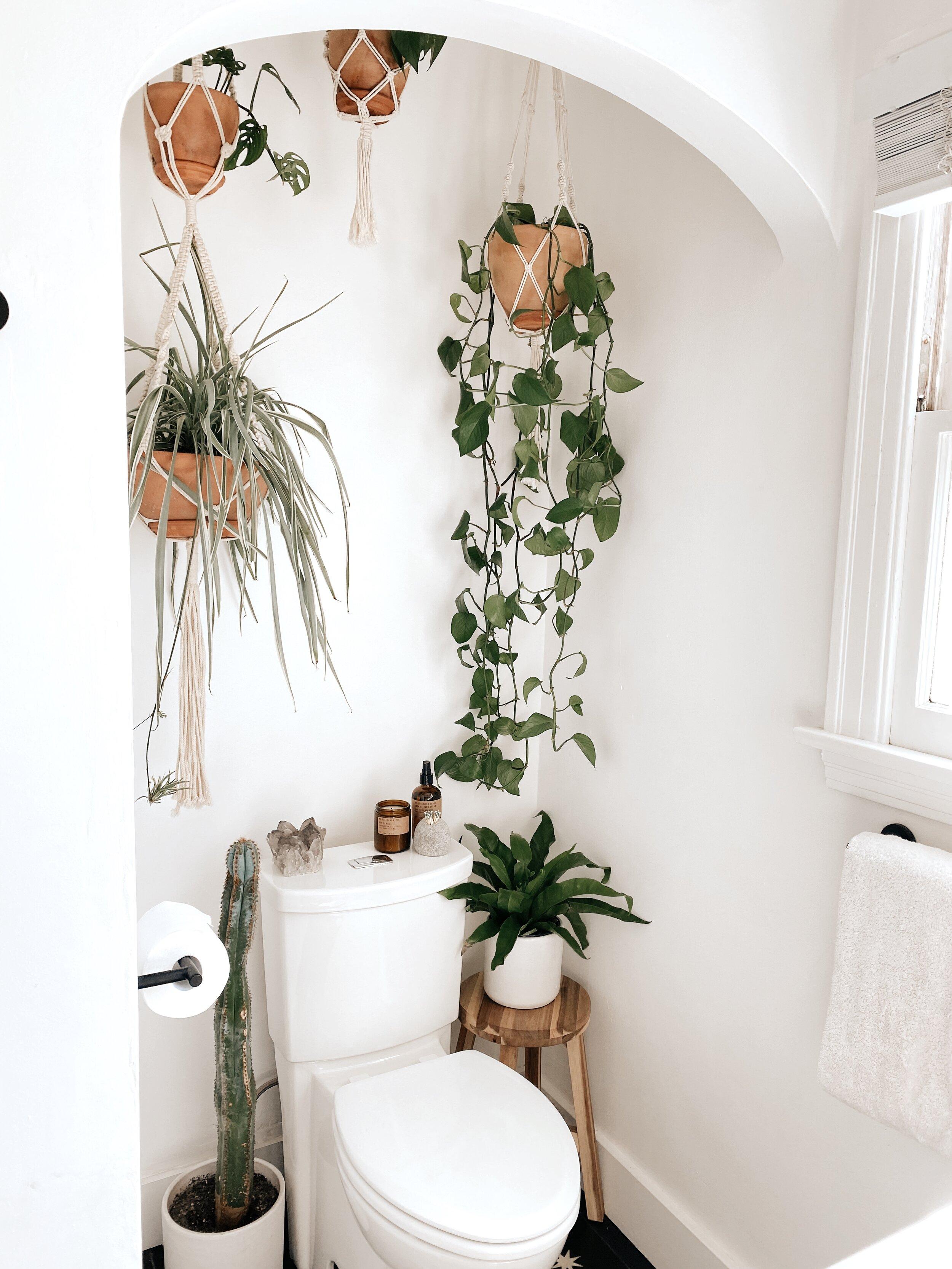 Layer textiles with macramé wall​ hangings for a cozy boho bathroom feel