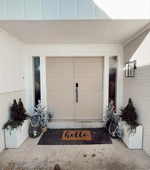Light wood double doors with sidelights and simple planter decor