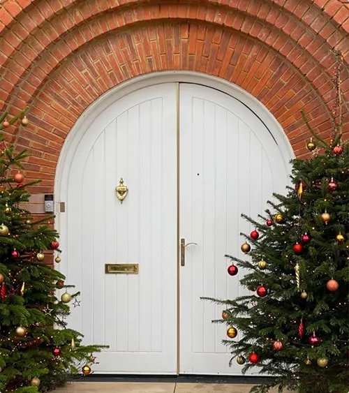 White vertical plank double doors decorated for holidays