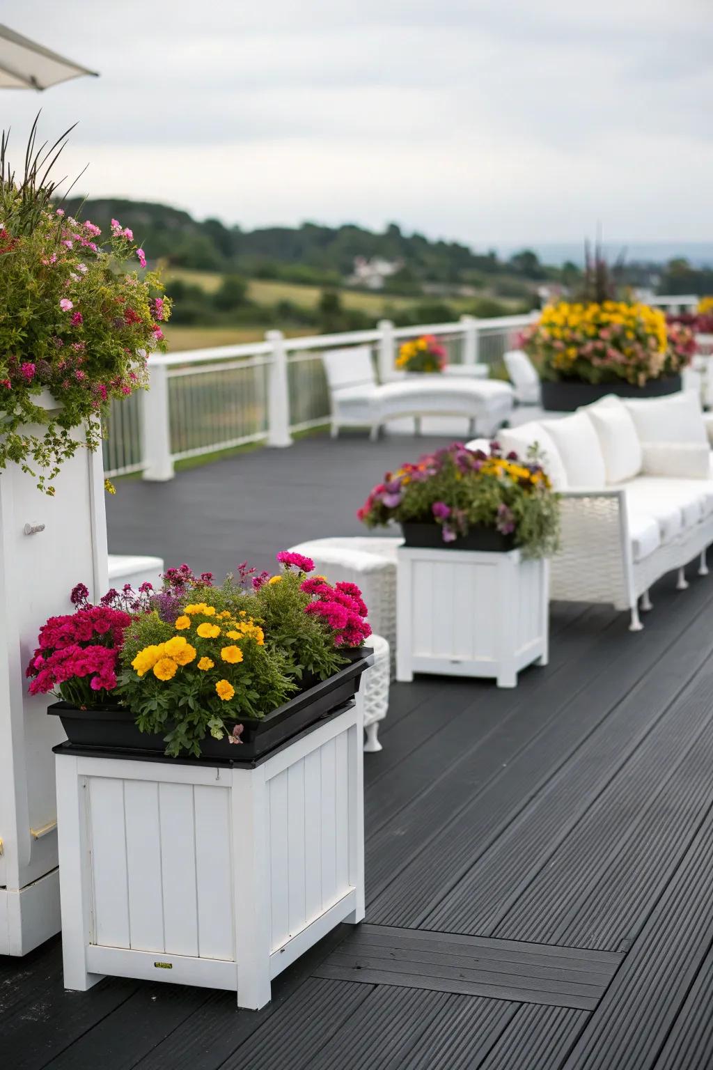 A bold black deck with striking white furniture and vibrant planters.