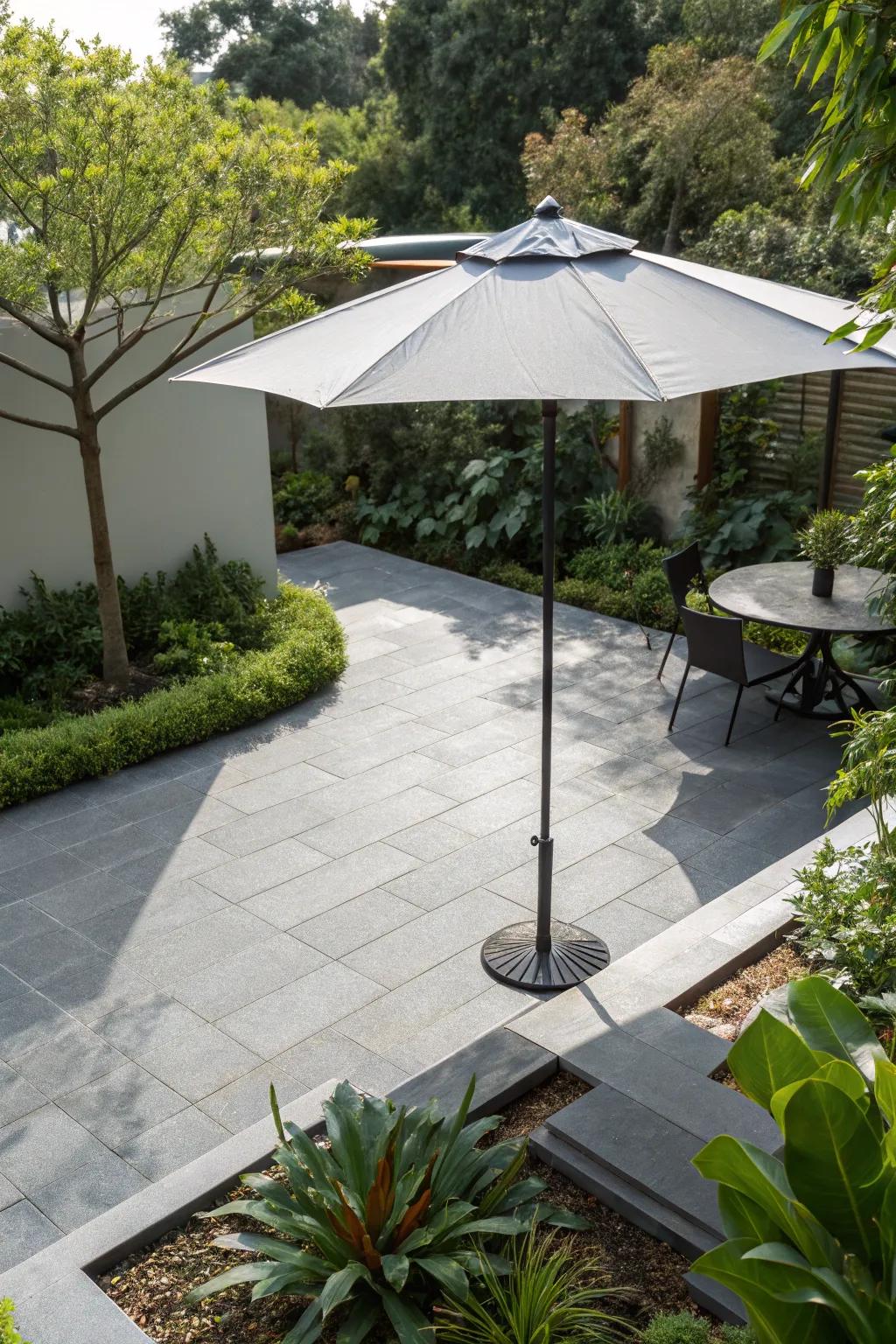 A modern umbrella provides shade on the grey patio.